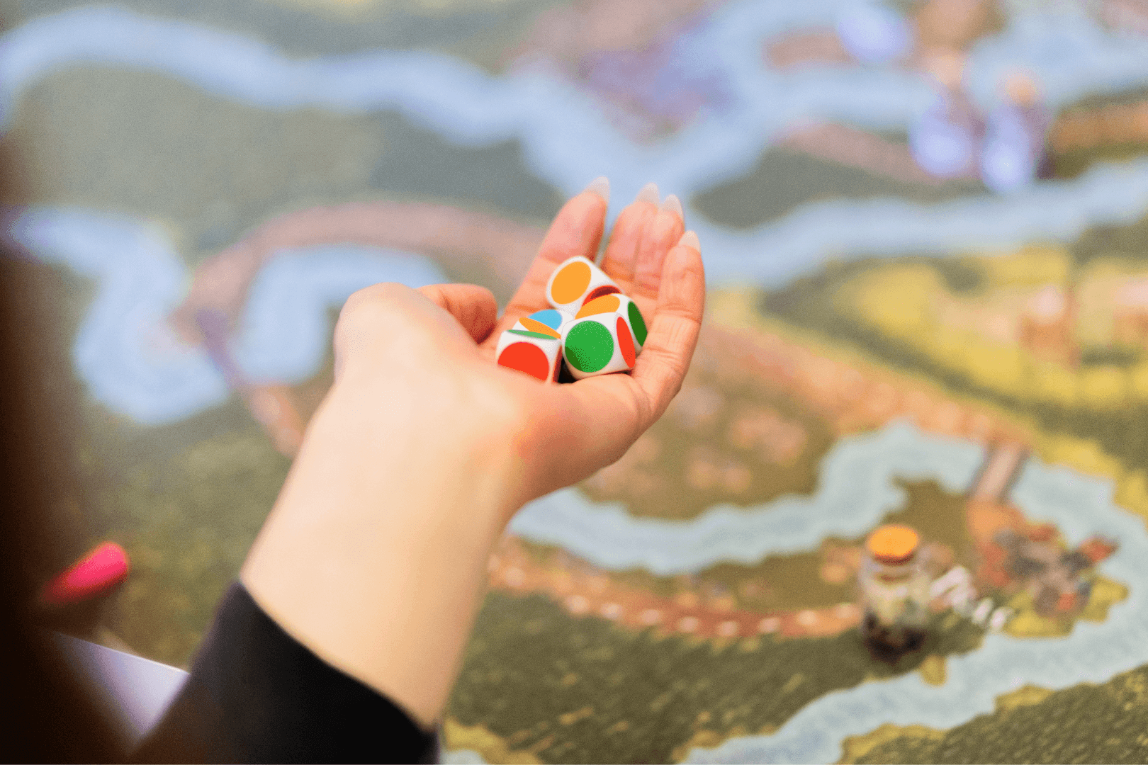 A handful of colourful dice over a fantasy map